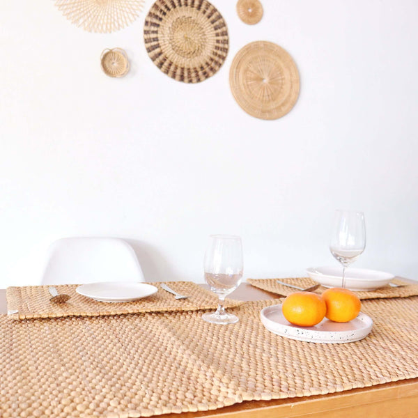 KAN TI CHA woven table runners on a dining table set with white plates, wine glasses and oranges