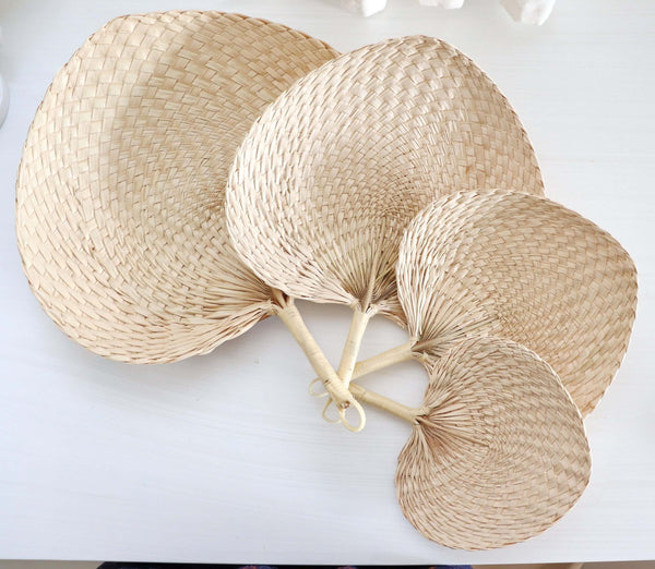 Palm Leaf Hand Fans, handwoven palm leaf fans with bamboo handles on a white table