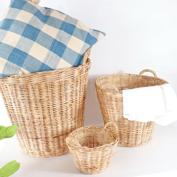 Handwoven rattan baskets styled with a cushion and towel