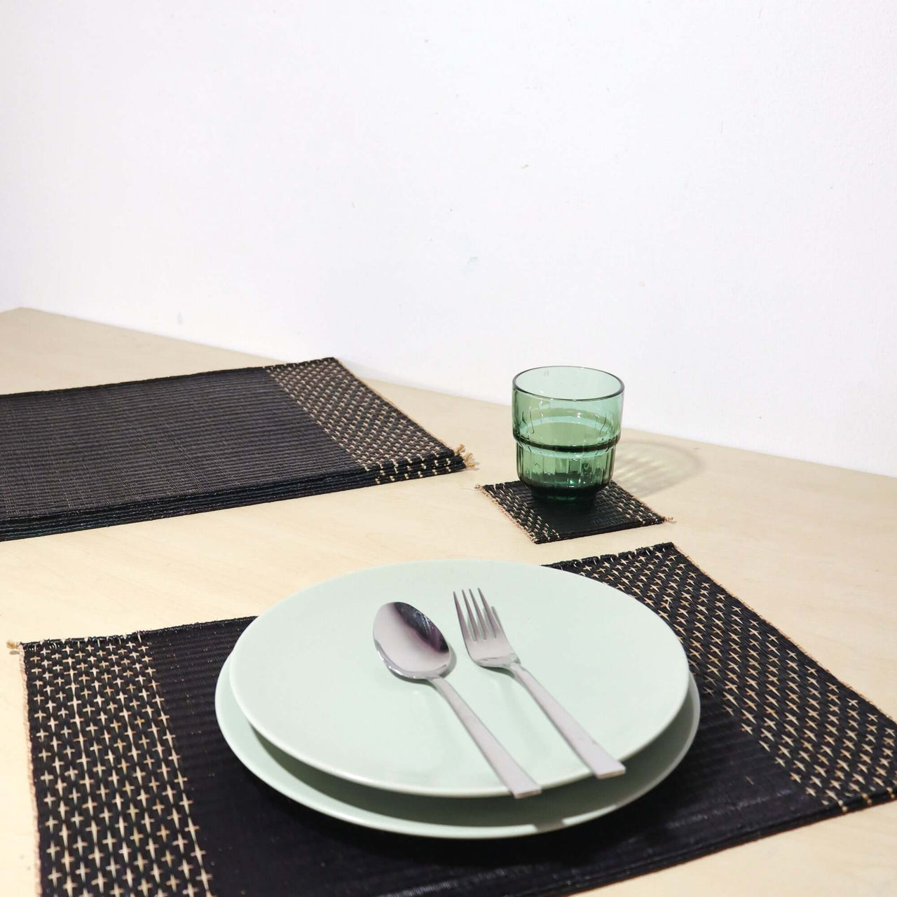 Lavila Handwoven Placemat set on a minimalist dining table with plates and glasses, showcasing elegance and texture.