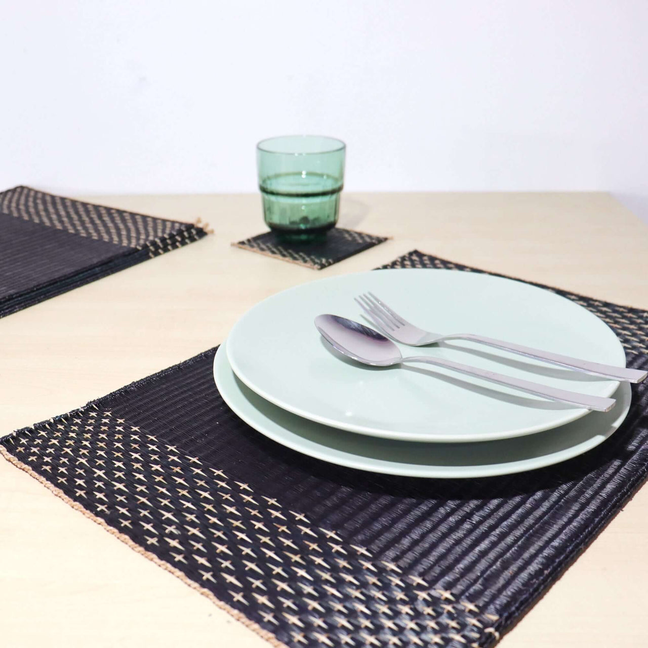 Elegant Lavila Handwoven Placemats on a dining table with plates and glassware, showcasing understated style.