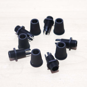 Black Cord Grips Lampshade Holder – Plastic Screw Style Cord Grip (20 pcs.) scattered on a wooden surface.