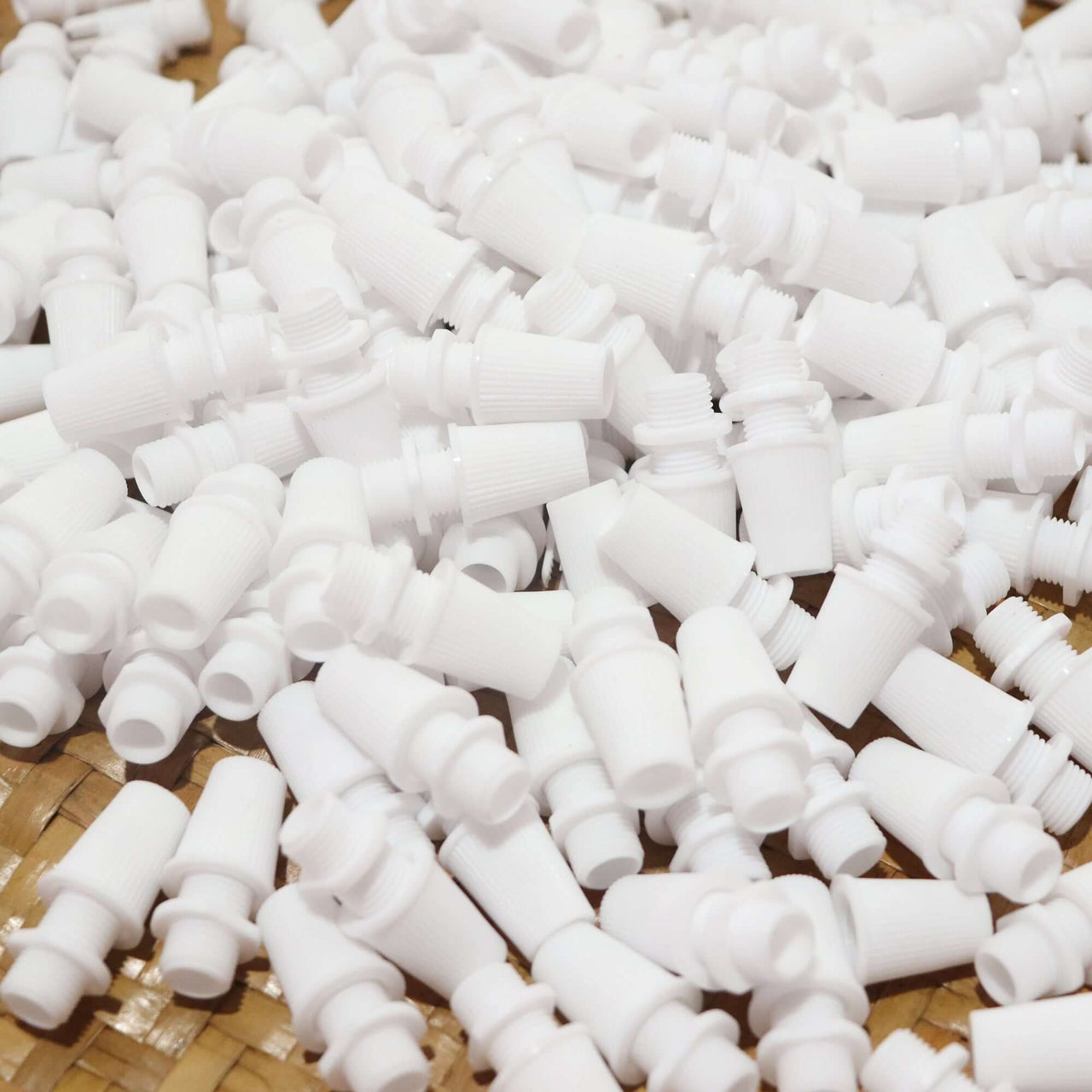 White Cord Grips Lampshade Holder – Plastic Screw Style Cord Grip (20 pcs.) scattered on a surface.