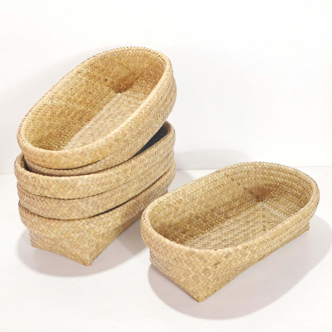 Nattalee Oval Pandanus Basket Natural - handwoven pandanus storage baskets stacked.