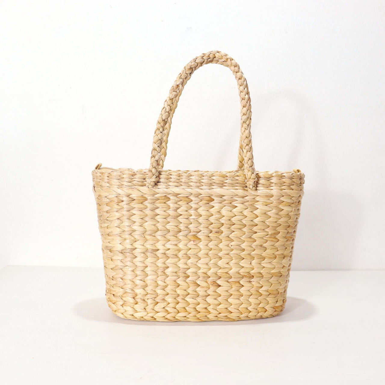Handwoven straw handbag with natural woven texture, by Thai artisans