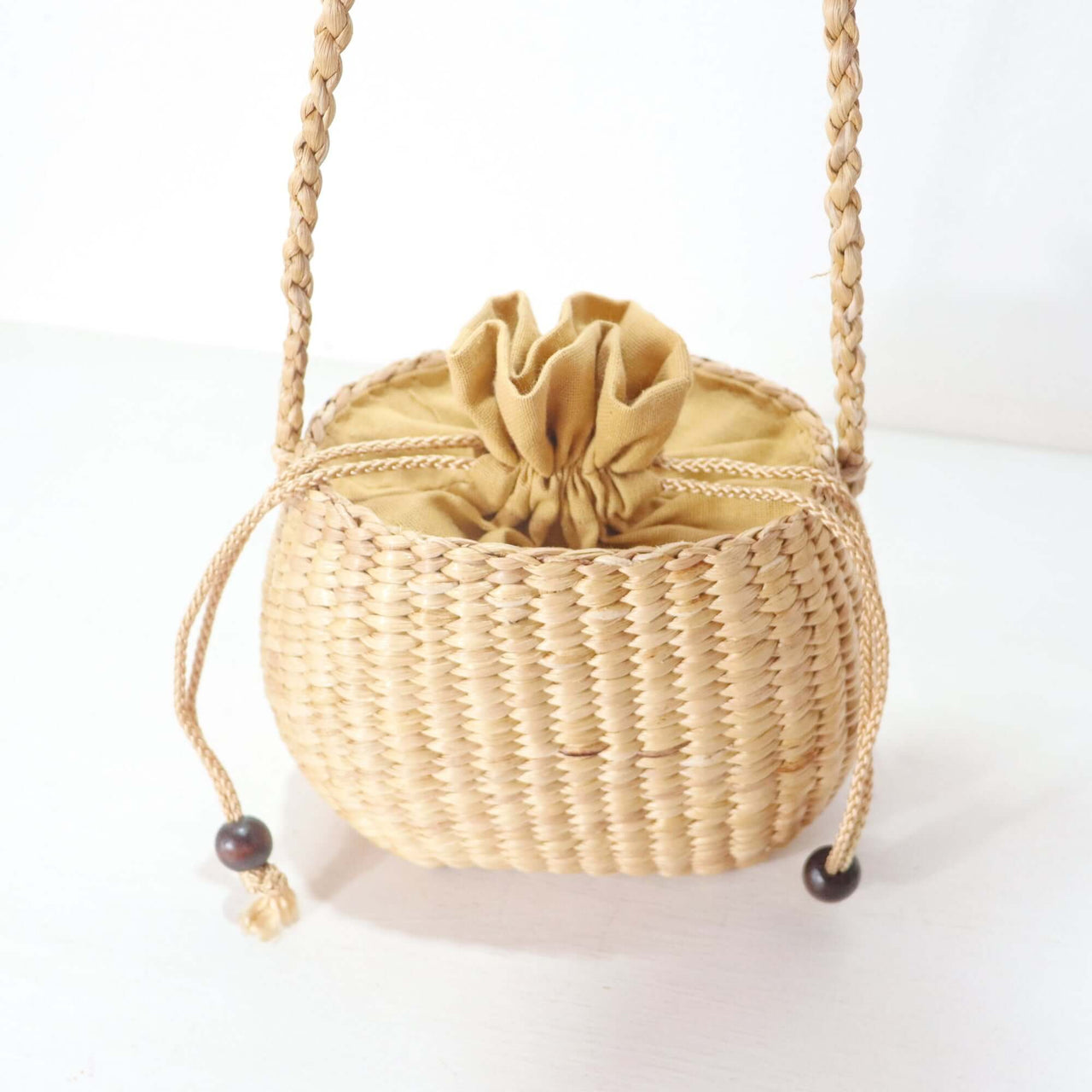 WANAREE - Cross Body Bag featuring a woven design with a drawstring closure and a braided strap.