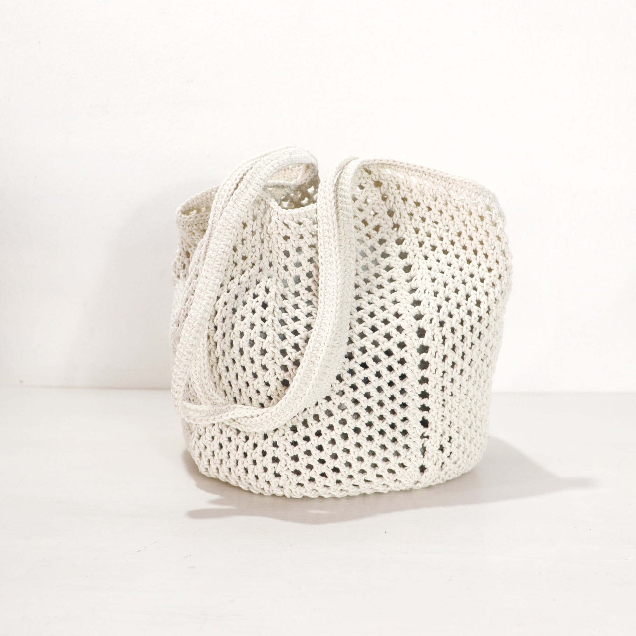 White Crochet Shoulder Bag showcasing its delicate weave and lightweight design against a neutral background.