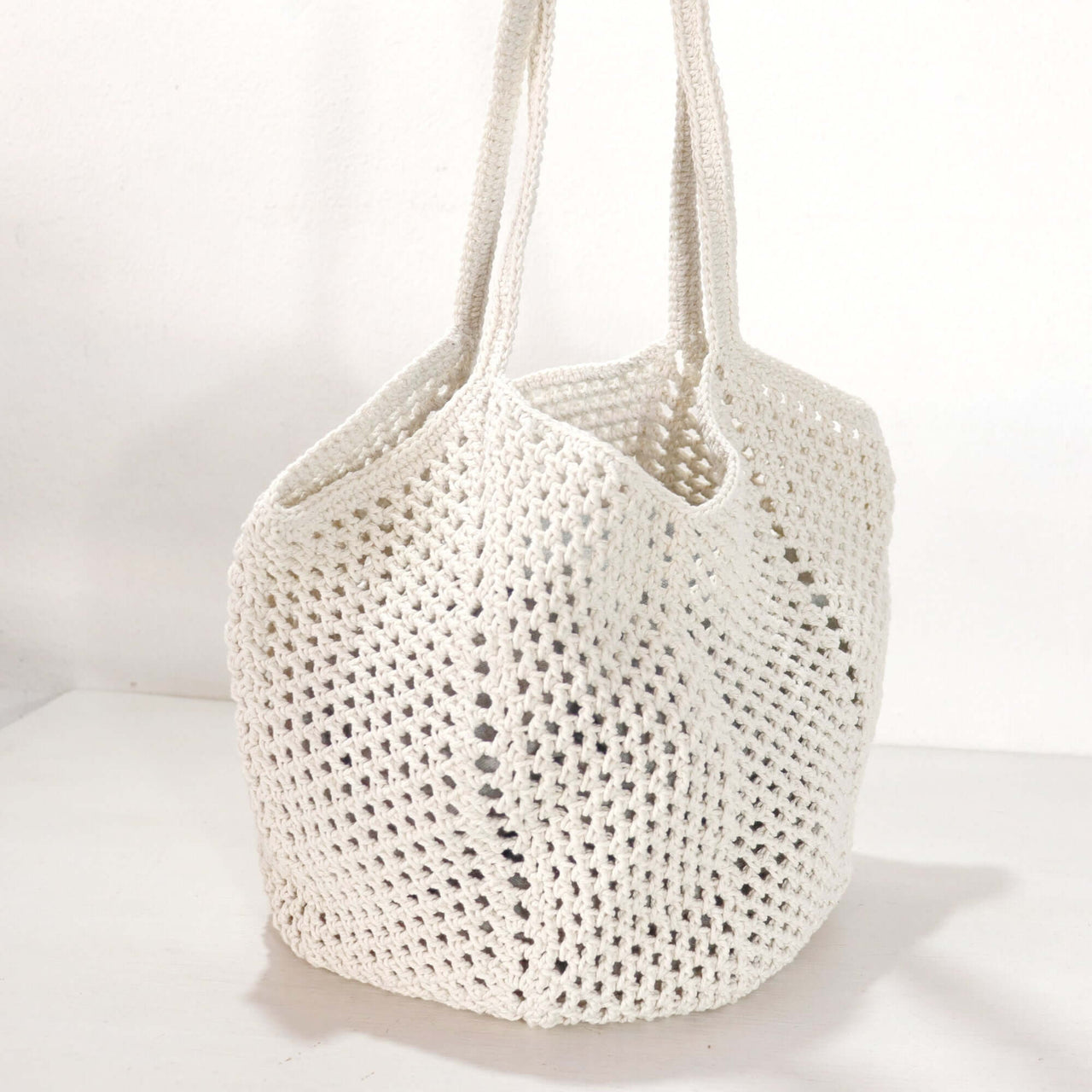 White Crochet Shoulder Bag showcasing a soft, lightweight design with a delicate weave and clean white tone.