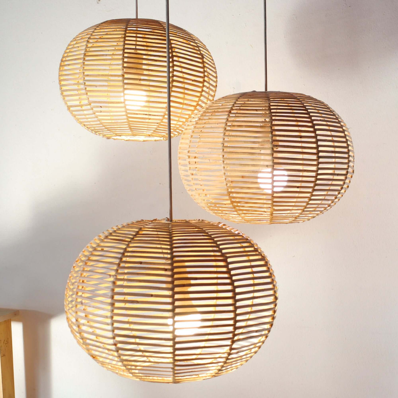 KAN — handwoven rattan pendant light with an open weave that diffuses soft golden light