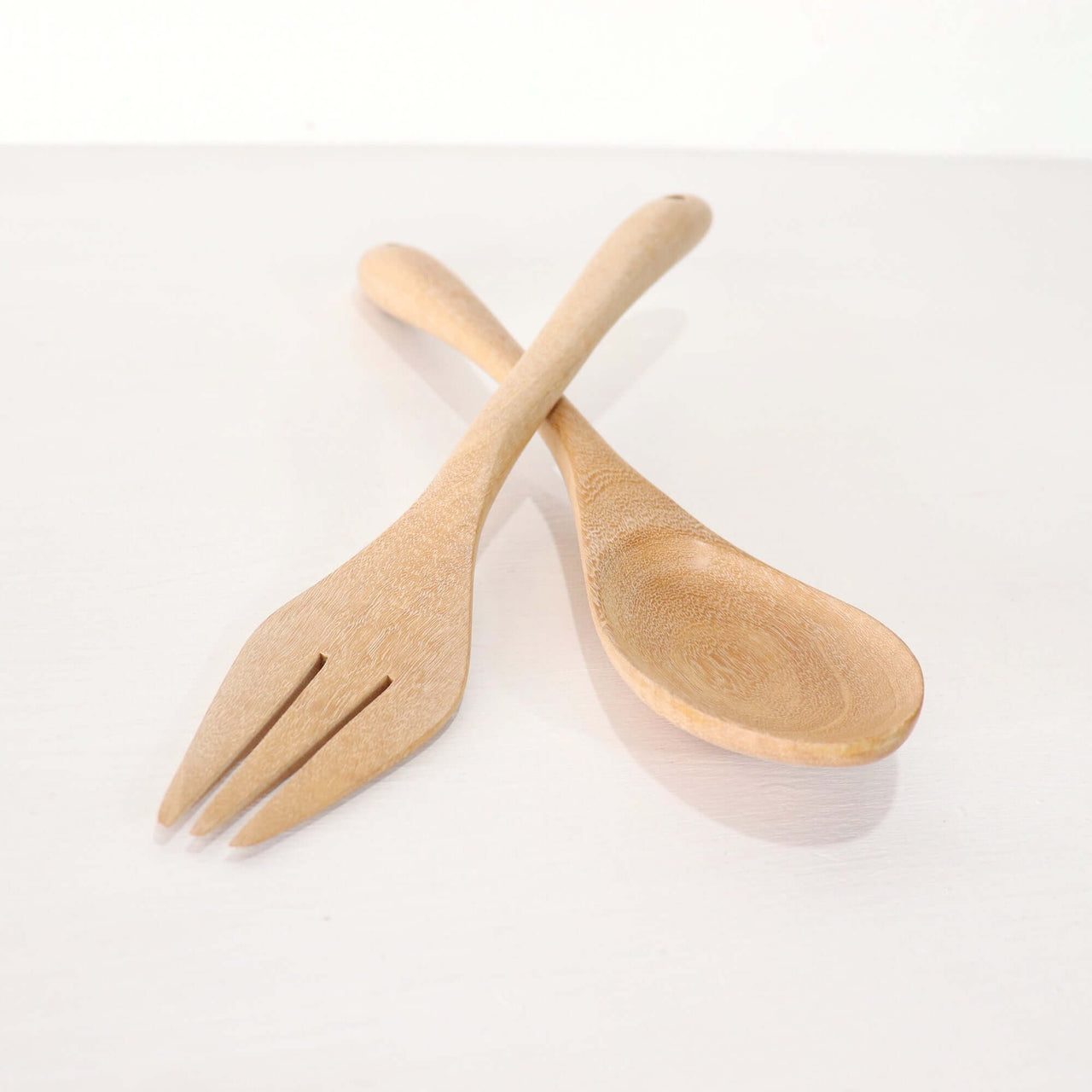 SA LIN THIP Wooden Salad Fork and Spoon Set elegantly resting on a white surface.
