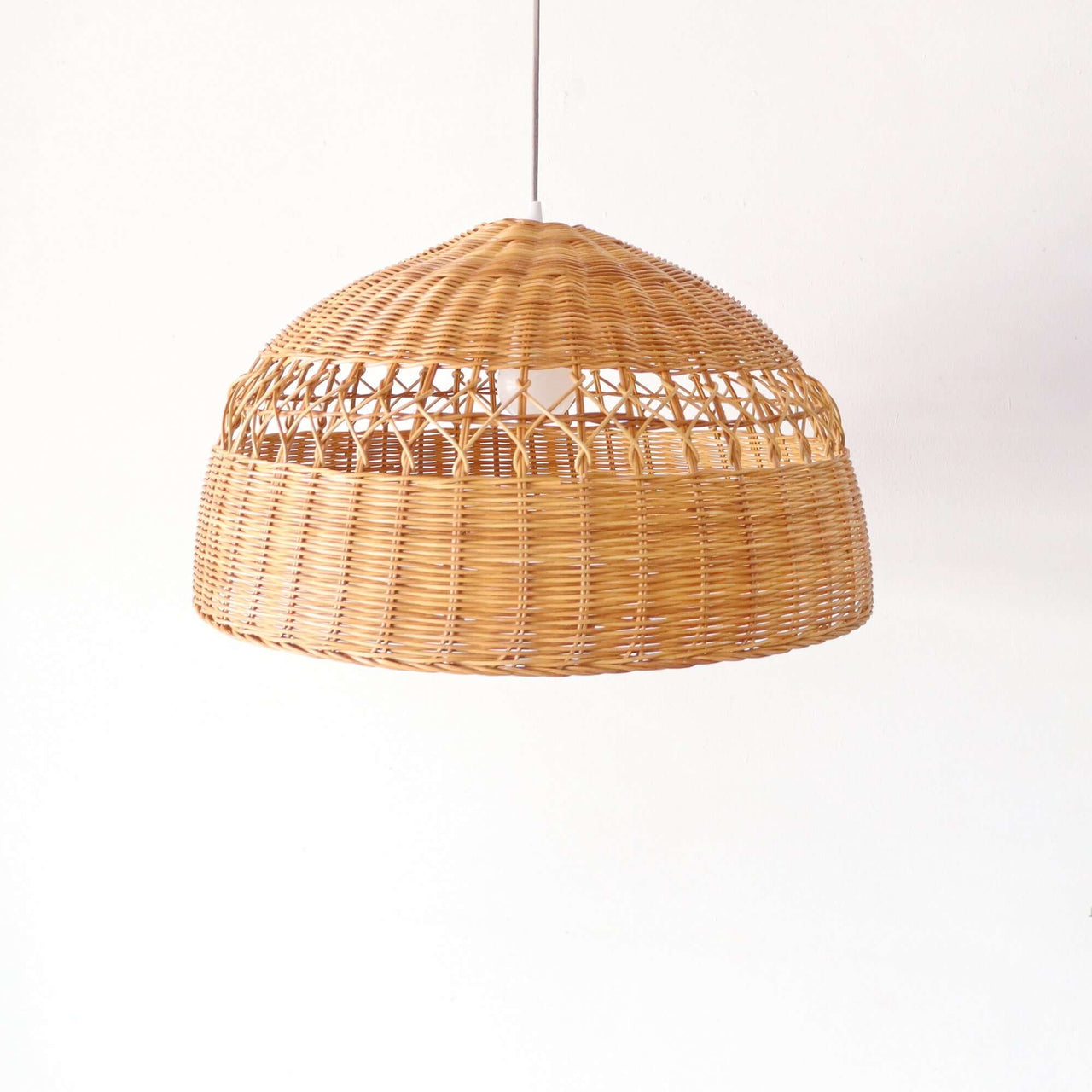 PARADEE — handwoven rattan pendant light with an open weave that diffuses soft golden light