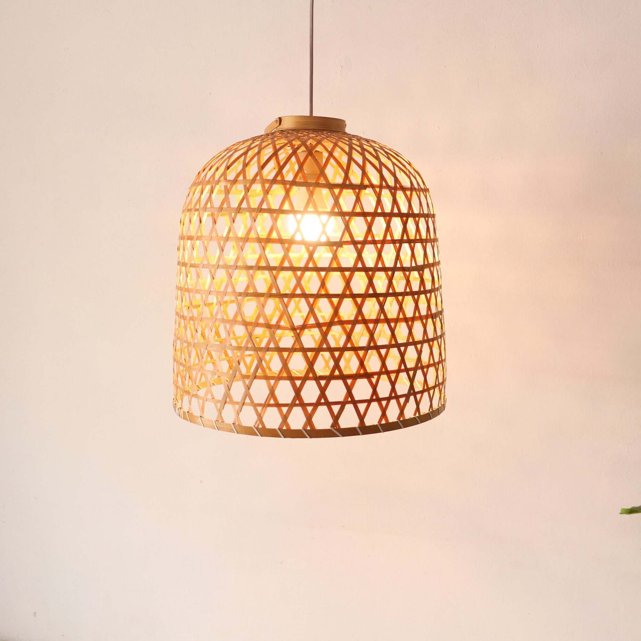 LAWAN — handwoven bamboo pendant light with an open weave that diffuses soft golden light