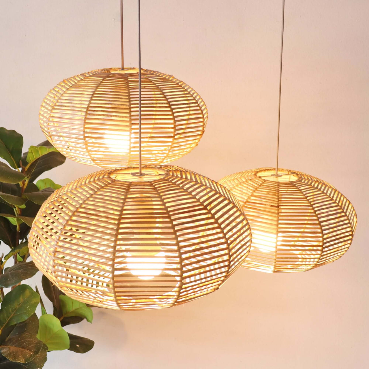 KAN WIN — handwoven rattan pendant light with an open weave that diffuses soft golden light