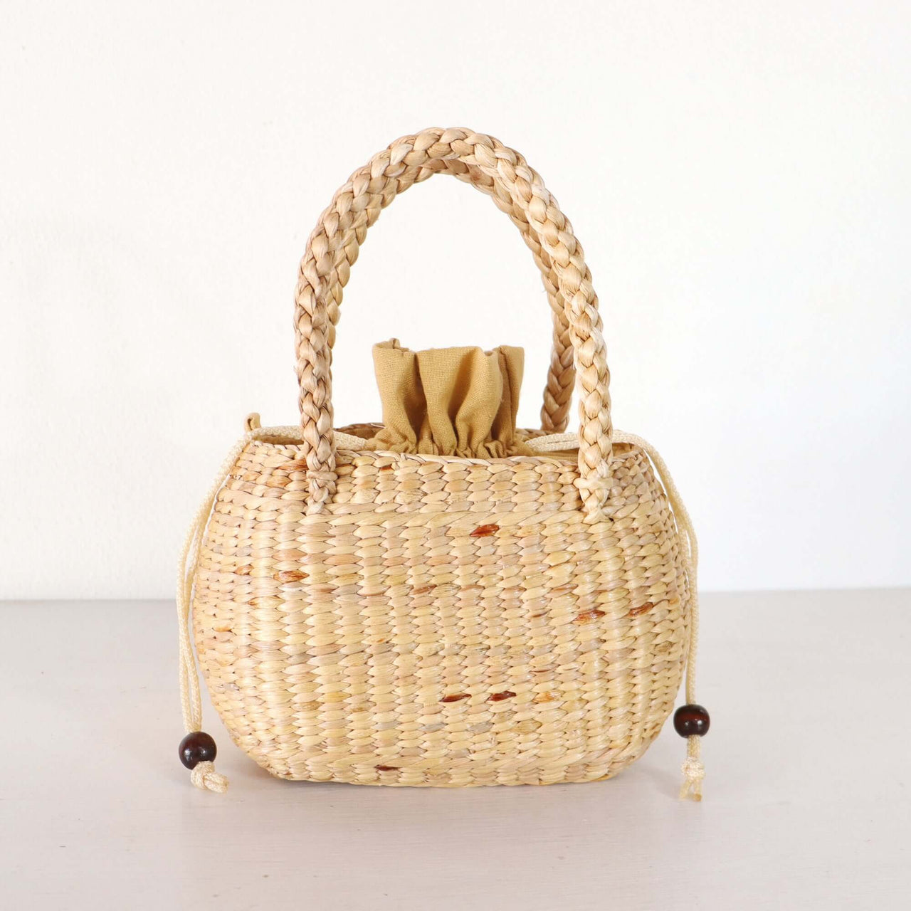 Handwoven straw basket bag with natural woven texture, by Thai artisans