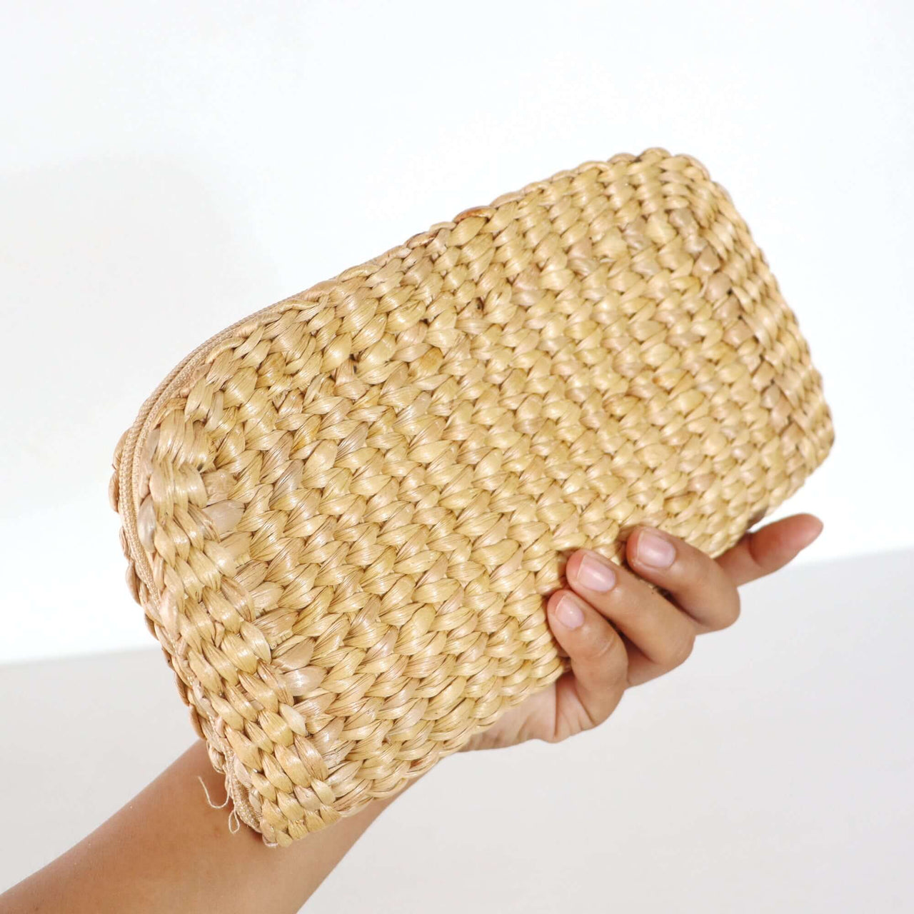 Handwoven straw clutch bag with natural woven texture, by Thai artisans