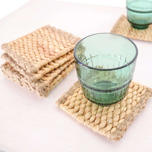 KA NOK PUN Water Hyacinth Boho Coaster Set of 4 displayed with a green glass on a neutral surface.