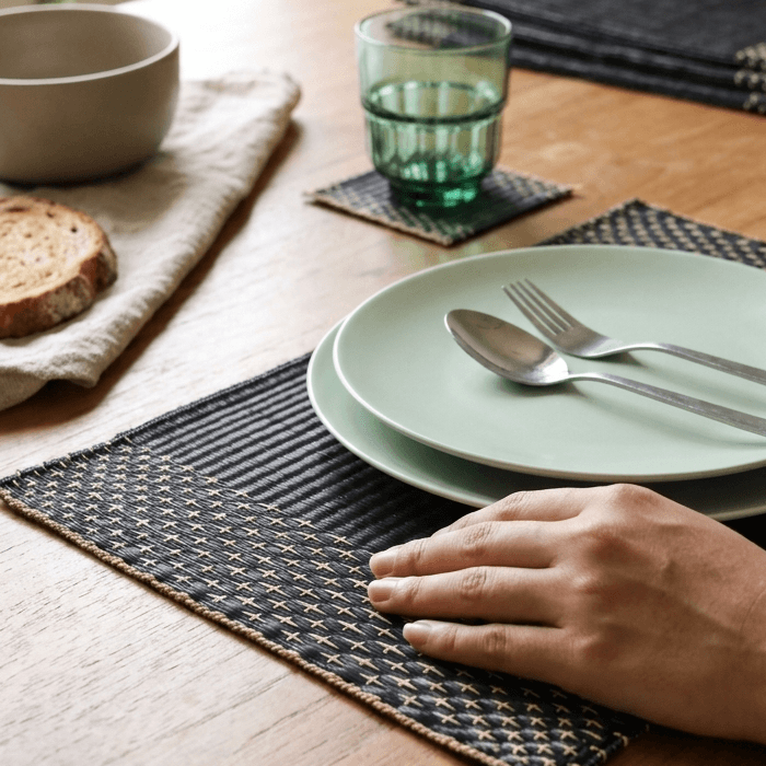 Elegant Lavila Handwoven Placemat styled with plates, cutlery, and a glass on a wooden dining table.