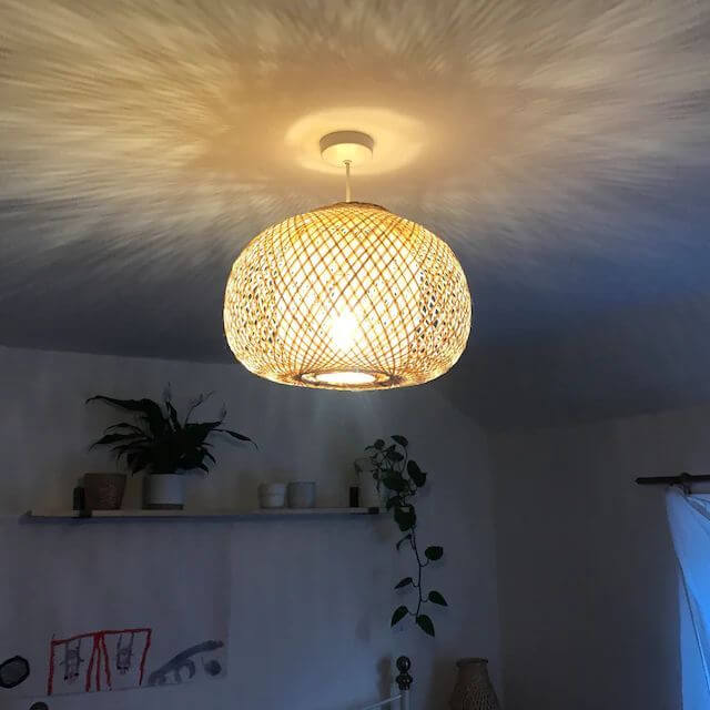 ARUNEE — handwoven bamboo pendant light with an open weave that diffuses soft golden light